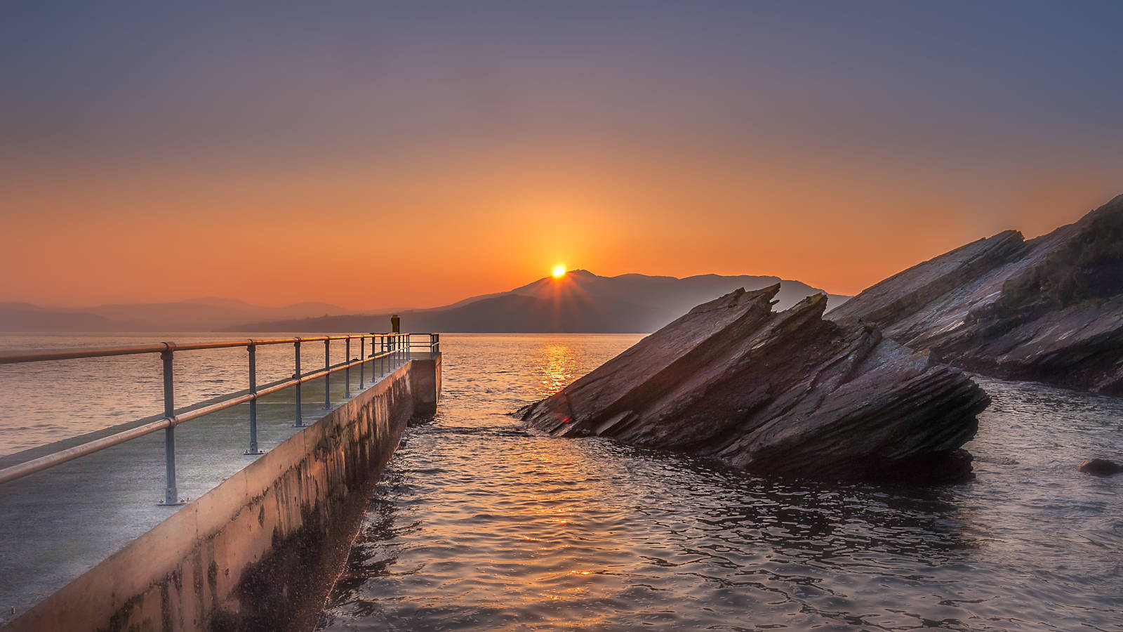 Photo of a sunset at the pier at Dunree Beach, County Donegal
